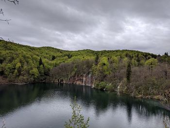 Scenic view of lake by trees against sky