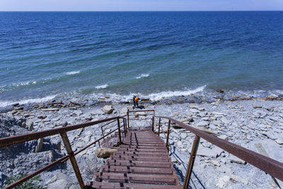 High angle view of staircase by sea against sky