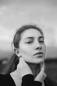 Portrait of young woman against sky