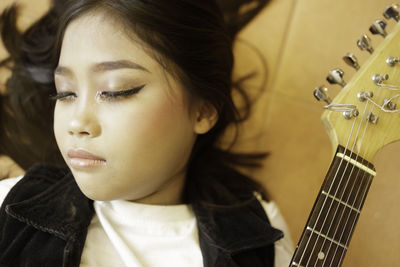 Close-up of teenage girl playing guitar