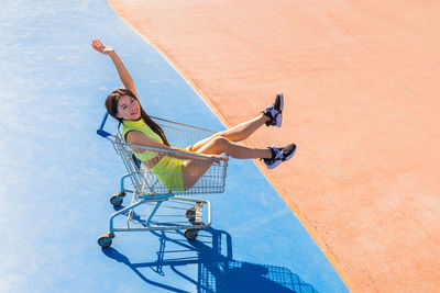 High angle view of young woman in shopping cart