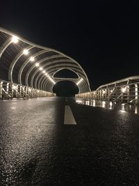Illuminated bridge against sky at night