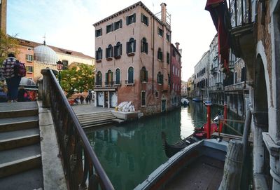 Canal amidst buildings in city against sky