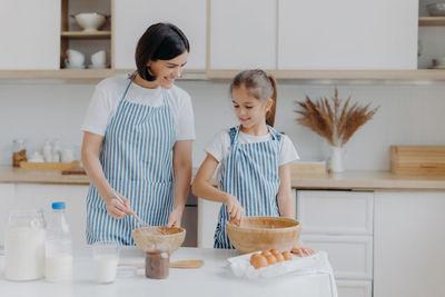 Mother and daughter preparing food at home