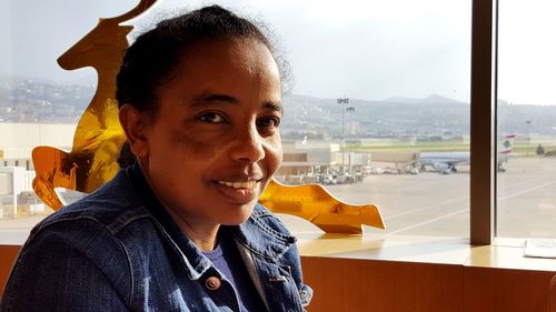 Close-up portrait of woman sitting at airport