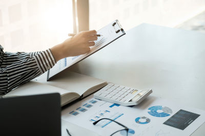 Midsection of businessman working on table