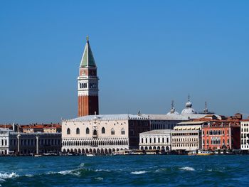 Historical buildings by grand canal against clear blue sky