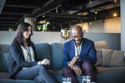 Smiling businessman and businesswoman sitting in office