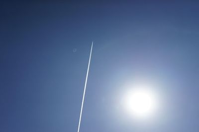 Low angle view of vapor trail against blue sky