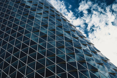 Low angle view of glass building against sky