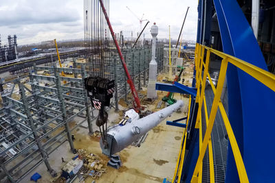 People working at construction site against sky