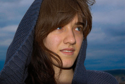 Close-up portrait of a beautiful young woman against sky