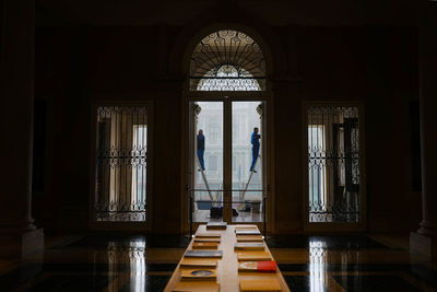 Mans cleaning museum windows