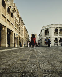 Rear view of women walking on historical building