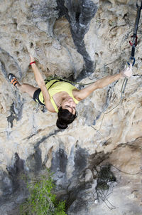 High angle view of woman climbing rock