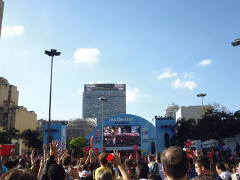 Crowd in city against sky