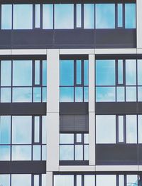 Low angle view of glass building against sky