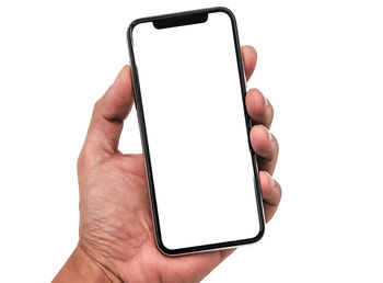 Cropped hand holding mobile phone against white background