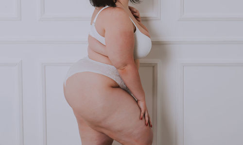 Midsection of woman standing against colored background