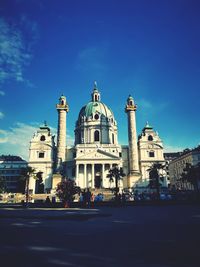 View of buildings in city against blue sky