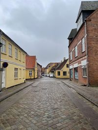 Empty alley amidst buildings in city