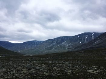 Scenic view of mountains against cloudy sky