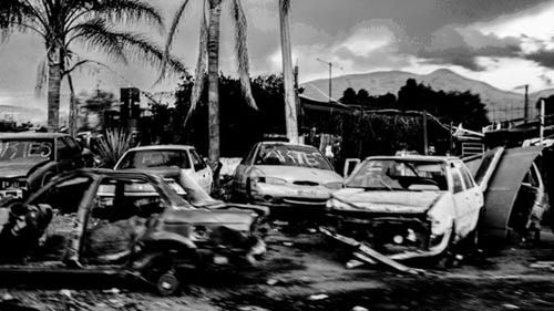 Cars on city street against sky