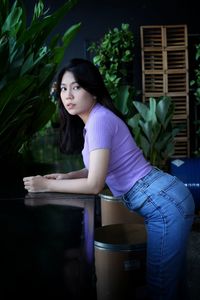 Portrait of young woman sitting on table