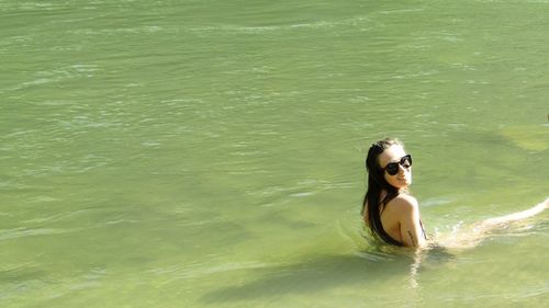 Portrait of smiling woman swimming in river