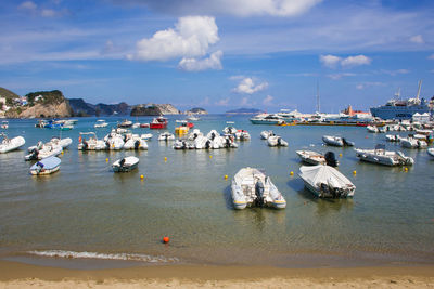 Sailboats moored on sea against sky