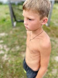 Boy looking away while standing outdoors