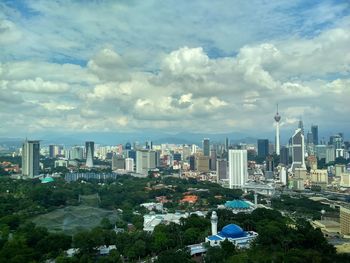 View of cityscape against cloudy sky