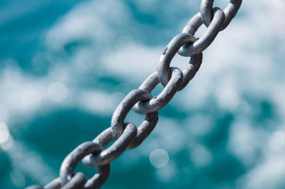 Close-up of chain against sea