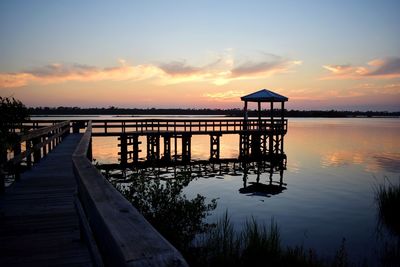 Pier over sea against sky during sunset