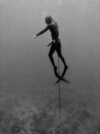 Silhouette man with arms raised in sea