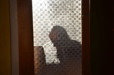 Close-up of woman standing against white wall