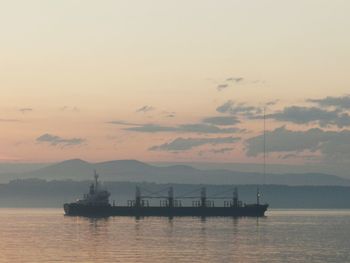 Silhouette boat in sea against sky during sunset