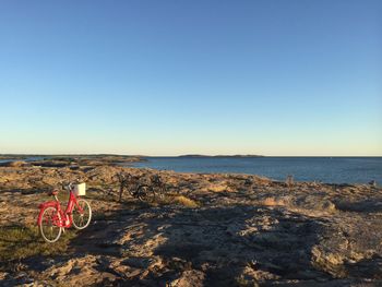 Bicycle by sea against clear sky