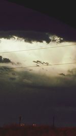 Silhouette of birds flying against dramatic sky