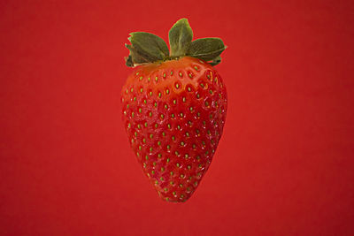 Close-up of strawberry against red background