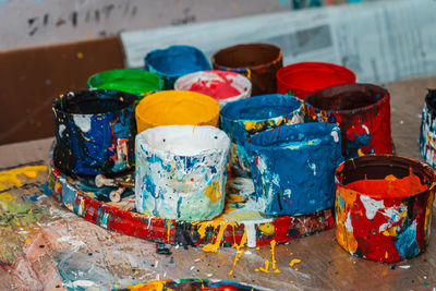 Jars of the artist with bright colors in the art workshop