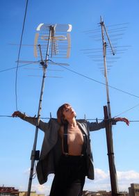 Low angle view of woman standing against sky