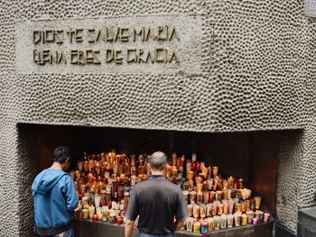 Rear view of people on table against wall