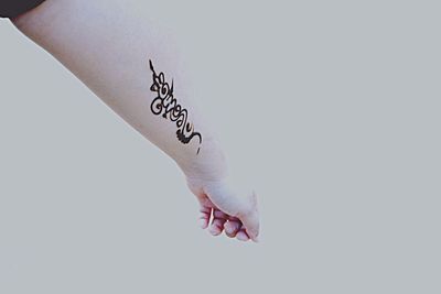 Close-up of hand on paper against white background