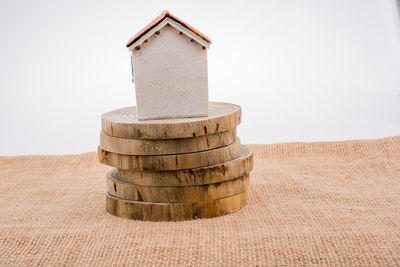 Close-up of model home on stack of wood against white background