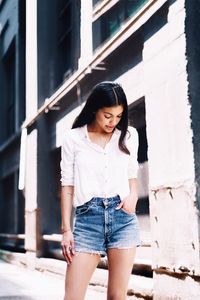 Portrait of woman standing against building