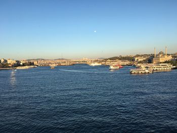 Scenic view of sea and buildings against clear blue sky