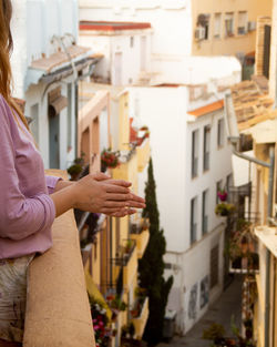 Girl applauding as a show of support for the nurses from the balcony