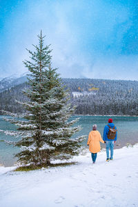 Rear view of man standing on snow covered land