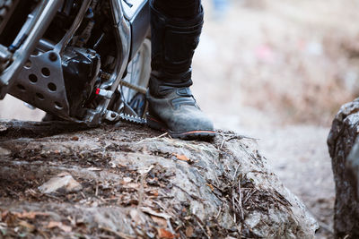 Low section of man standing on motorcycle